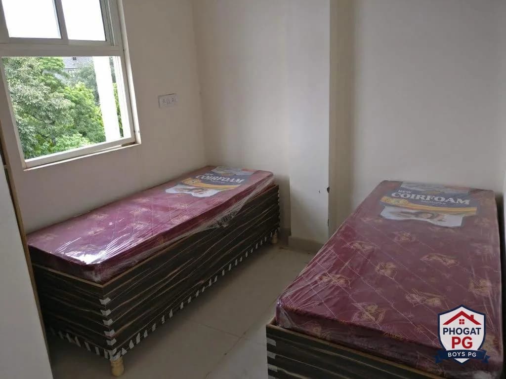 Two beds beside a large window in a Phogat PG room