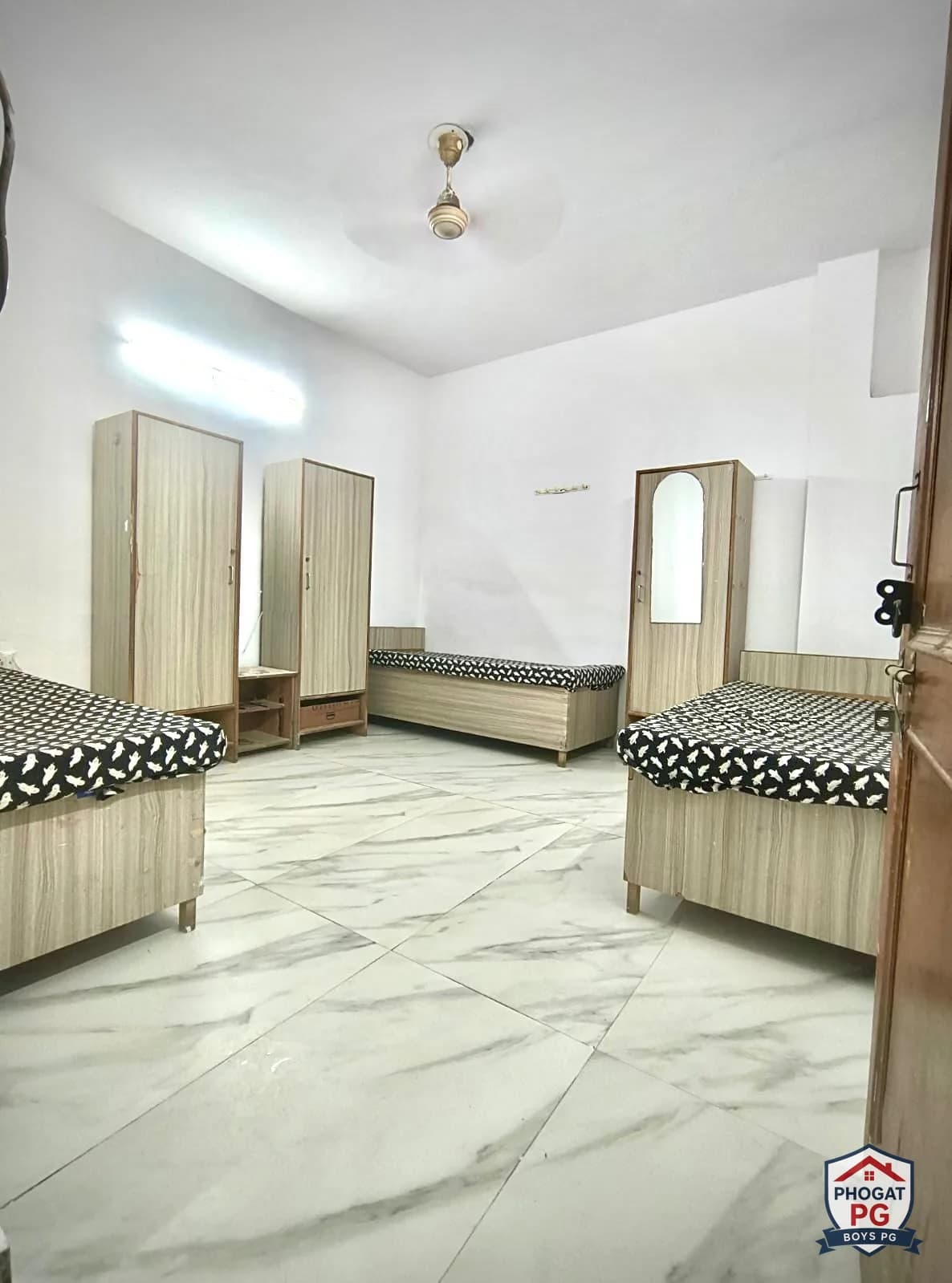 Three single beds and individual wardrobes in a shared Phogat PG room